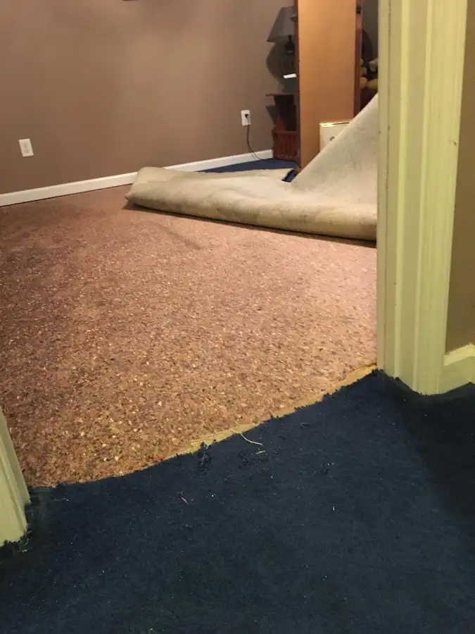 Carpet pad removal revealing water damage during Water Mitigation Services in Crowley